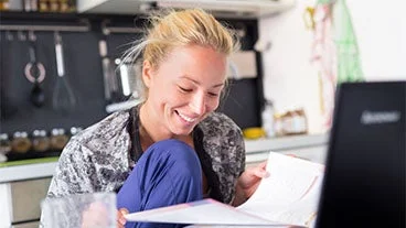 An Open University student studying in her kitchen.
